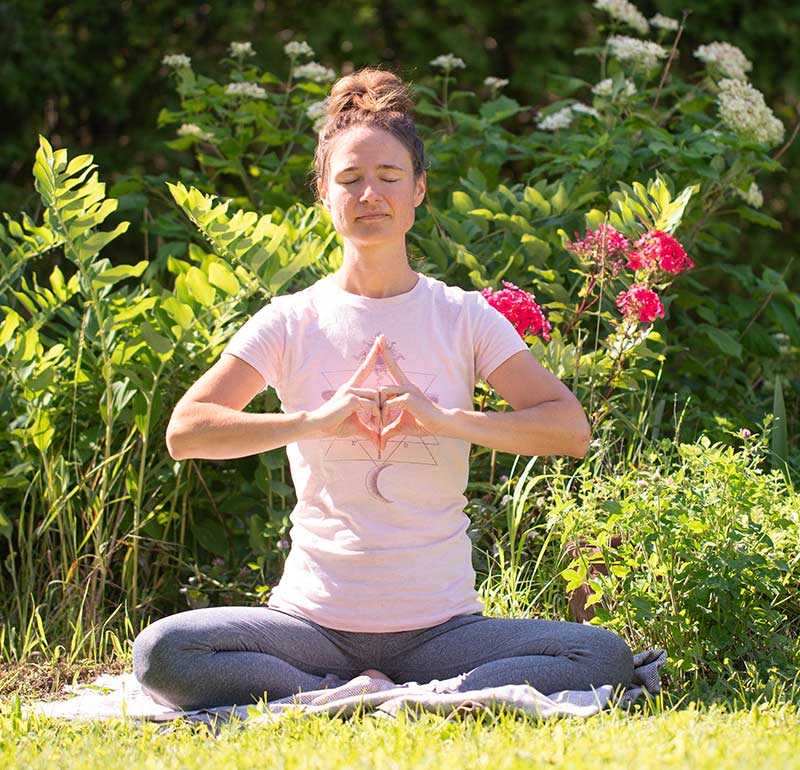 Nancy Fournier médite assise avec des fleurs